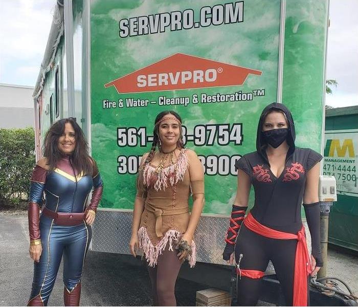 Three SERVPRO techs dressed in Halloween costumes in front of SERVPRO trailer